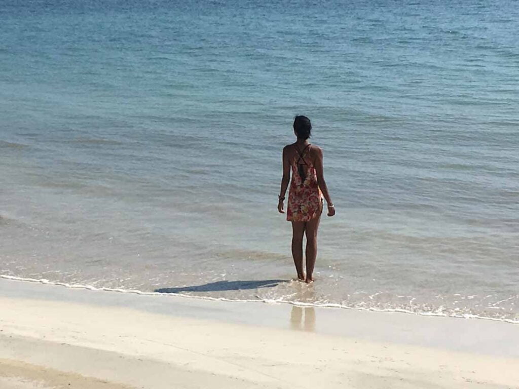 Image of me during my travels standing on a bright sunny beach staring out to sea, searching for the answers to the questions I was asking.