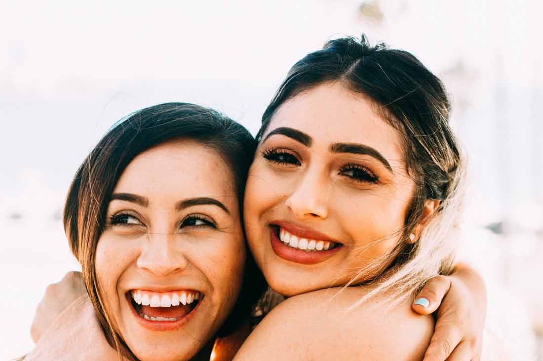 Social anxiety exists only in the mind, if you can move through it, you'll find that your relationships become deeper, you meet new people, your life begins to flow again. Image of two women smiling and hugging.